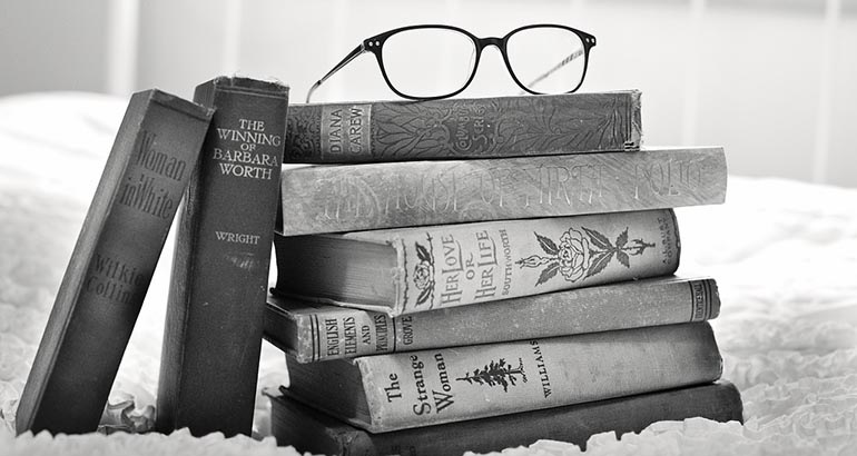Foto de varios libros con lentes arriba.
