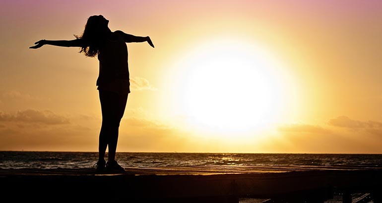 mujer estirándose en atardecer